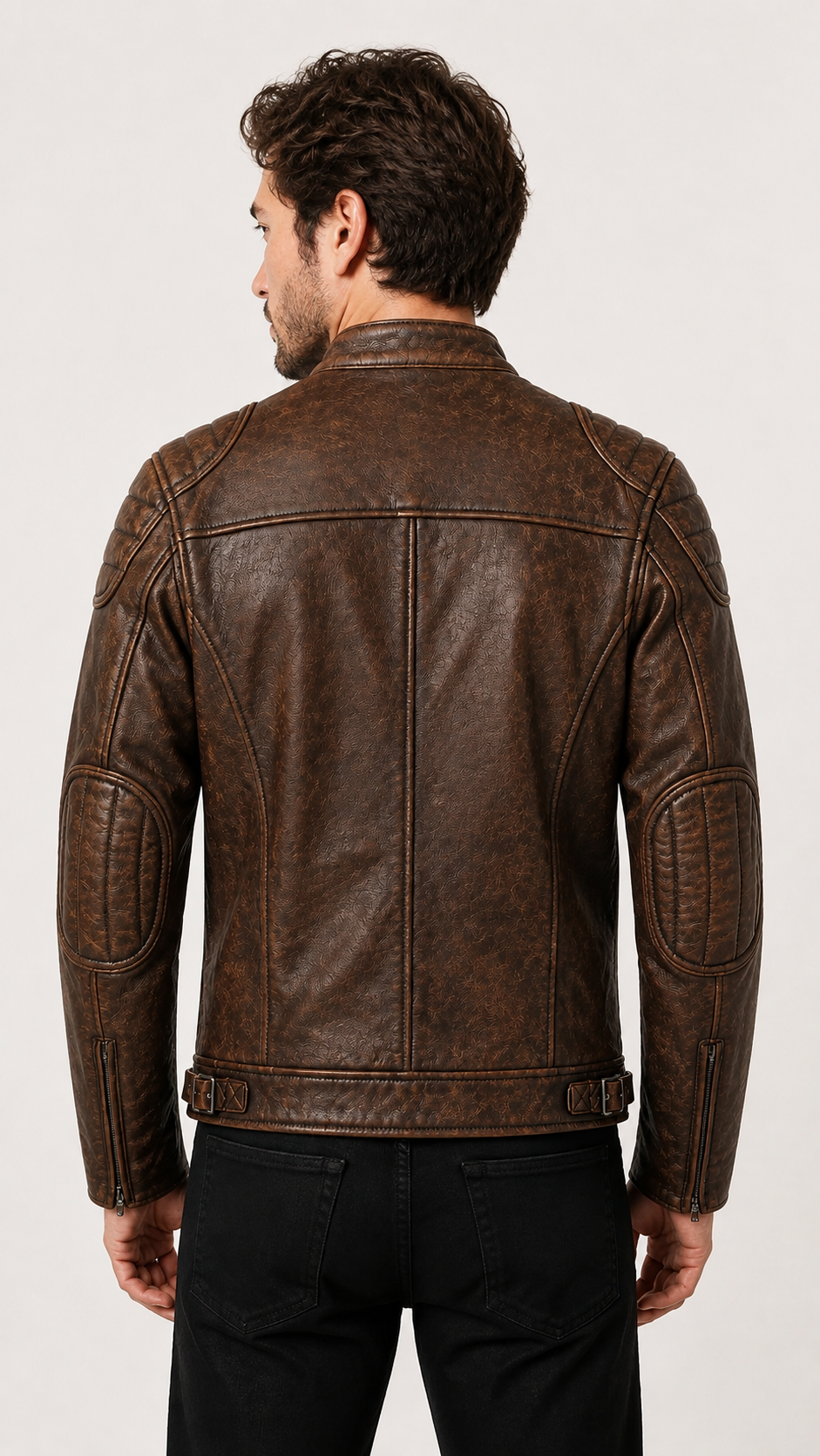Back view of the distressed brown biker jacket worn with black trousers — British model